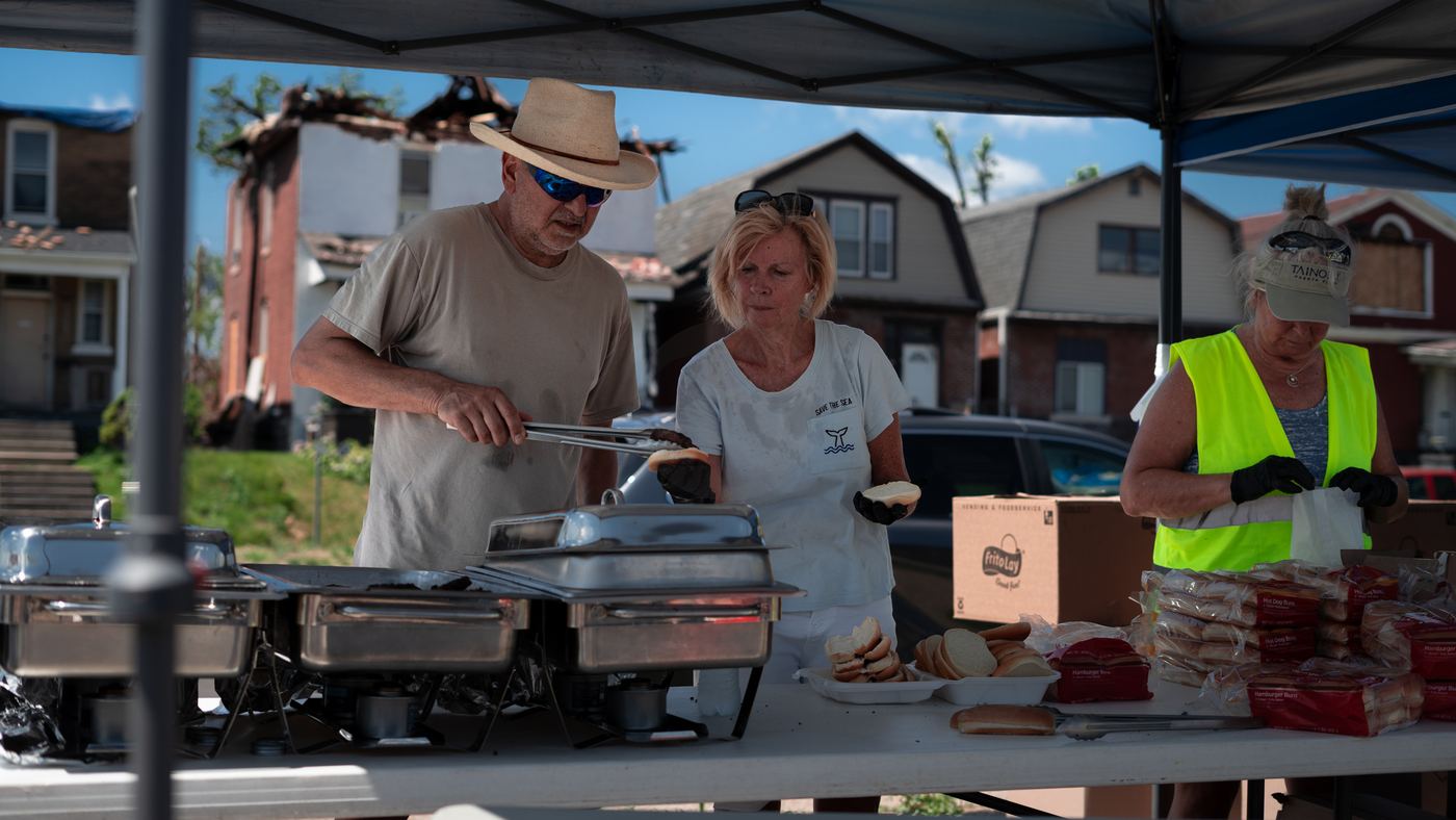 Volunteers serving burgers under a tent