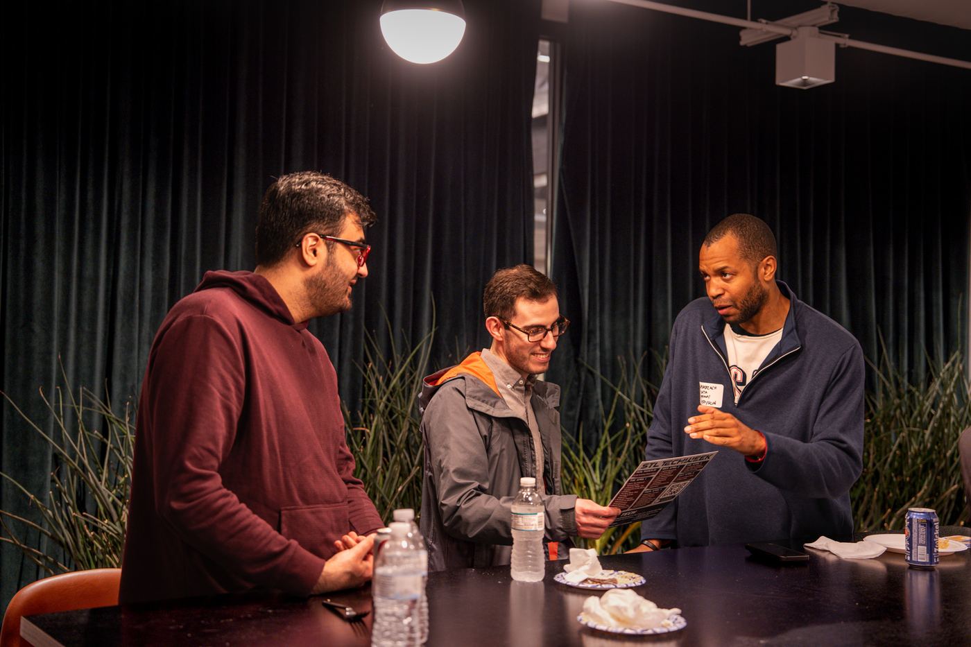 Three attendees reading the STL TechWeek schedule